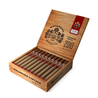Open wooden box of Macanudo Vintage 2010 cigars with visible cigars inside on a white background