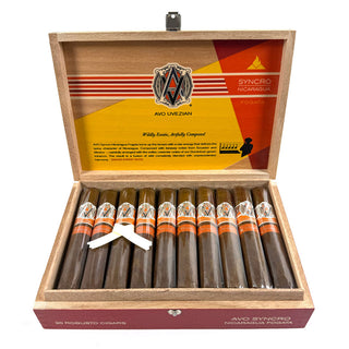 Open wooden box of cigars with AVO Syncro Nicaragua Fogata branding on a white background