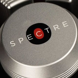Close-up of a metallic object with 'SPECTRE' branding on a dark background