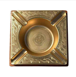 Gold ashtray with intricate designs on a white background