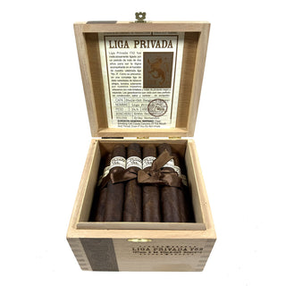 Open wooden Liga Privada T52 cigar box containing cigars with a visible label inside.
