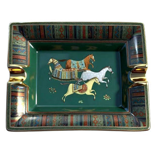 Decorative cigar ashtray with horses and geometric patterns on a green background