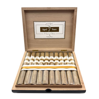 Open wooden cigar box with Rocky Patel Vintage 1999 Connecticut cigars inside on a white background
