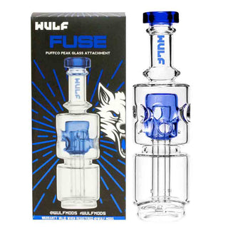 Clear Puffco Peak glass smoking attachment with blue accents next to Wulf branded packaging